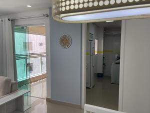 un couloir avec une porte en verre dans une chambre dans l'établissement Lindo Apto Guarujá 50m da Praia das Pitangueiras, à Guarujá