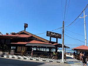 un restaurant avec une enseigne au bord d'une rue dans l'établissement Lindo Apto Guarujá 50m da Praia das Pitangueiras, à Guarujá