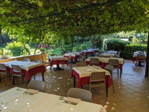 Ristorante Le Rasole في غارْدا: غرفة طعام مع طاولات وكراسي وبارينس