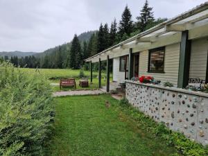 a house with a bench next to a yard at River Run Ranch - Telemark in Drangedal