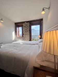 1 dormitorio con 2 camas blancas y ventana en Casa Rural Basiver - Habitación Pico Samelar, en Armaño