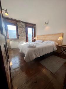 um quarto com 2 camas e uma parede de pedra em Casa Rural Basiver - Habitación Pico Samelar em Armaño