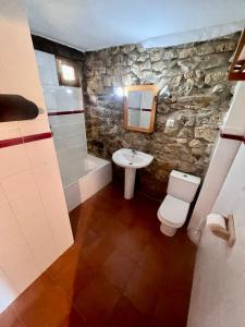 Baño de piedra con lavabo y aseo en Casa Rural Basiver - Habitación Pico Samelar en Armaño