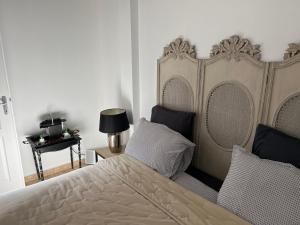 een slaapkamer met een bed met een groot hoofdeinde bij Gîte de l’abbaye in Saint-Jean-aux-Bois