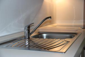 a sink in a kitchen with a faucet at Claudia's Apartment Blu in Alba di Canazei