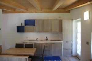 a kitchen with wooden cabinets and a wooden table at Claudia's Apartment Blu in Alba di Canazei