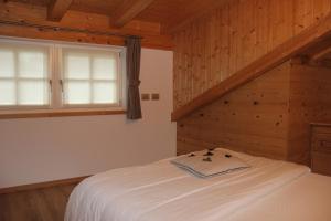 a bedroom with a white bed in a wooden room at Claudia's Apartment Blu in Alba di Canazei