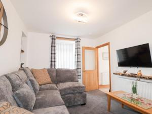 a living room with a couch and a flat screen tv at Corner Cottage in Buckie