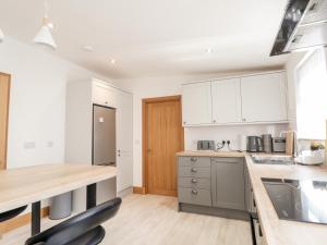 a kitchen with white cabinets and a wooden counter top at Corner Cottage in Buckie