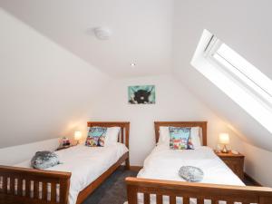 two twin beds in a room with a attic at Corner Cottage in Buckie