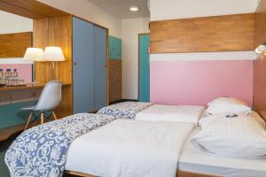 a hotel room with two beds and a desk at Hotel Oleander - Oleander Resort in Strunjan