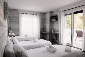 a room with two beds and a desk and a window at Les Chambres du Diu Biban in Hossegor