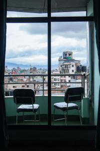 dwa krzesła siedzące przed oknem w obiekcie Yaksa Hotel Pvt. Ltd. w Katmandu