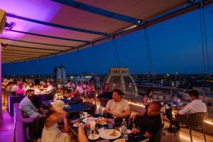 a group of people sitting at tables in a restaurant at Hotel The Square Milano Duomo - Preferred Hotels & Resorts in Milan