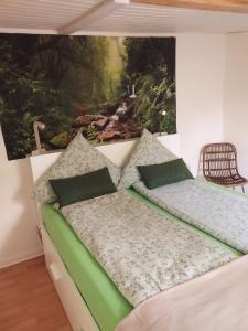 a bed in a room with a painting on the wall at Appartement an der Bicke in Dehringhausen