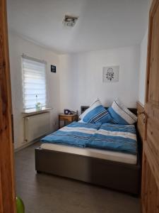 een slaapkamer met een bed met blauwe lakens en een raam bij Pension Giovanni in Cochem