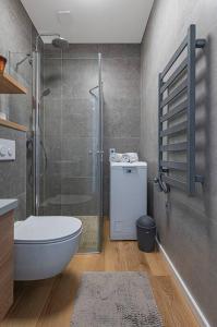 ein Bad mit einer Dusche, einem WC und einem Waschbecken in der Unterkunft Comfortable 1 BD Old Town Apartment by Hostlovers in Kaunas
