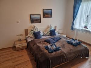 1 dormitorio con 1 cama grande con almohadas azules en Pension Heuhexe, en Fladungen