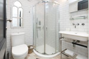 a bathroom with a shower and a toilet and a sink at Lovely 1BR Flat, Prime Location Bloomsbury, Euston in London