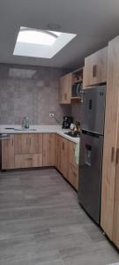 uma cozinha com armários de madeira e uma geladeira de aço inoxidável em CONDOMINIO LA ISABELLA ANAPOIMA em Anapoima