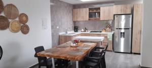 uma cozinha com uma mesa de madeira e uma geladeira em CONDOMINIO LA ISABELLA ANAPOIMA em Anapoima