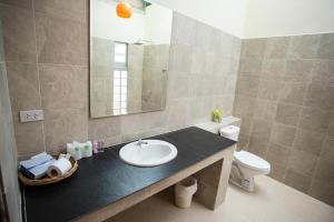 a bathroom with a sink and a toilet and a mirror at Be Fine Sabuy Hotel and Resort in Surat Thani