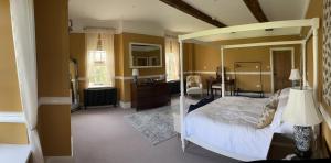 a bedroom with a canopy bed and a kitchen at Winsley Park Farm in Leominster