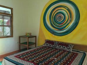 1 dormitorio con 1 cama con una pintura en la pared en A Place of True Colors, en Pottuvil