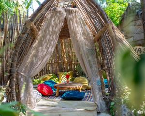 cenador con sillas y mesa en The Nest Boutique Resort, en Paje