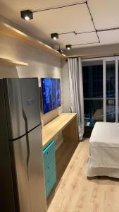 um quarto com um frigorífico e uma cama. em Studio Moderno próximo ao Metrô em São Paulo