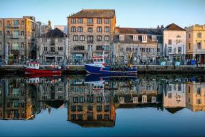 a group of boats sitting in the water near buildings at New Modern Apartment With FREE Private Parking in Plymouth