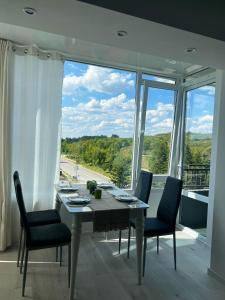 comedor con mesa y sillas y ventana grande en Тристаен апартамент Park View, en Targóvishte