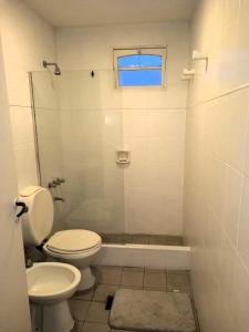 a bathroom with a toilet and a shower and a sink at Temporarios Santiago in Santiago del Estero