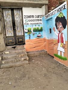 Une porte menant à une maison avec un tableau. dans l'établissement Zohra Guest House, à Assouan