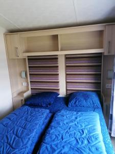 ein Schlafzimmer mit einem Bett mit blauen Kissen in der Unterkunft RBR 211 - Beach Resort Kamperland in Kamperland + 15 Fotos