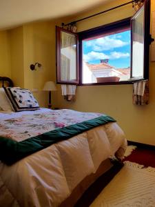 um quarto com uma cama e uma grande janela em El lagar de Lolo em Hontanares de Eresma