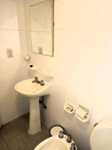 y baño con lavabo, aseo y espejo. en Temporarios Santiago en Santiago del Estero