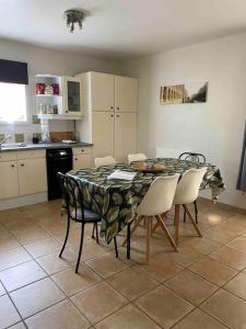cocina con mesa y sillas en una habitación en Maison avec jardin au cœur du Bassin d'Arcachon en Gujan-Mestras