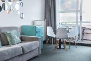 ein Wohnzimmer mit einem Sofa, Stühlen und einem Tisch in der Unterkunft Hotel Oleander - Oleander Resort in Strunjan