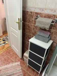 a bathroom with a toilet and a shelf with towels at Stan na dan Apartman Stella in Sombor +43 photos