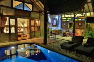 a house with a swimming pool and a living room at Villas SAMALAMA Gili Trawangan in Gili Trawangan +62 photos