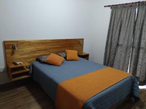 a bedroom with a bed with a wooden headboard at Sol Pampa in Concordia