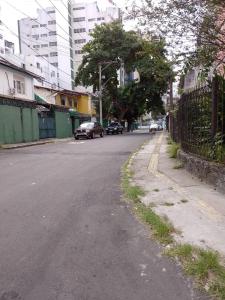 an empty street with cars parked on the side of the road at hostel barra in Salvador