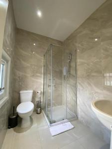 een badkamer met een douche, een toilet en een wastafel bij Holloway Suites - Next To Emirates Stadium - Private Bathroom - Shared Kitchen in Londen