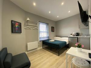 een slaapkamer met een bed en een tafel in een kamer bij Holloway Suites - Next To Emirates Stadium - Private Bathroom - Shared Kitchen in Londen
