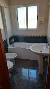 y baño con 2 lavabos, bañera y aseo. en Hotel restaurante Palacio Fes, en Murcia