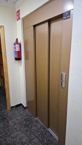 a elevator door in a room with a fire extinguisher at Hotel restaurante Palacio Fes in Murcia