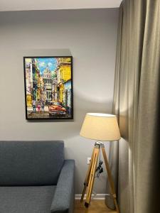 um quarto com um sofá, um candeeiro e um quadro em Dan apartment Tirana em Tirana