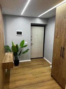 uma sala vazia com uma porta e um vaso de plantas em Dan apartment Tirana em Tirana