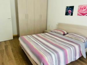 ein Schlafzimmer mit einem Bett mit einer rosa Rose an der Wand in der Unterkunft Casa di Nancy a Valdobbiadene 1(Unesco) in Valdobbiadene